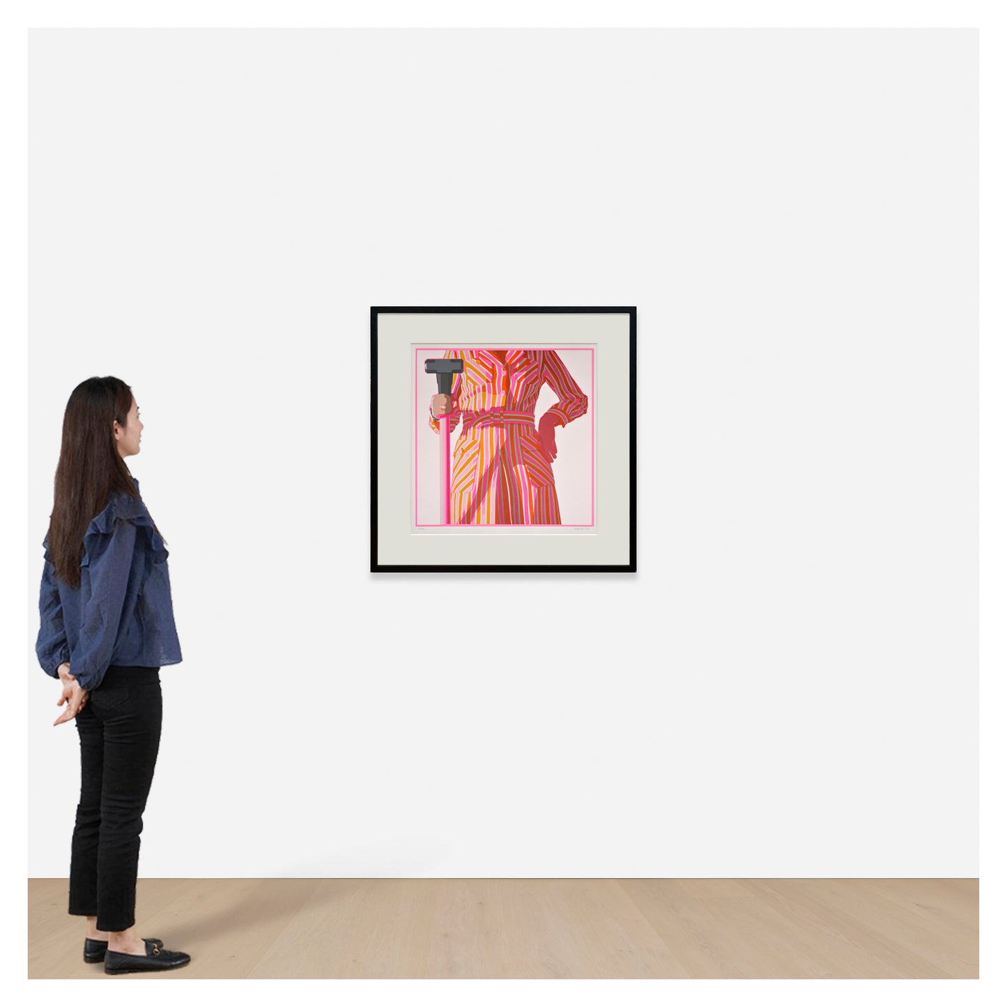 Woman looking at a framed artwork of a person in a colorful outfit on a white wall. Kelly Reemtsen. Dropshop by Phillips.
