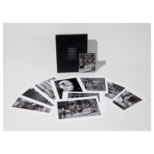 Collection of black and white Ruth Orkin photos from American Girl in Italy, a portfolio box, and an exhibition catalogue on a light gray background