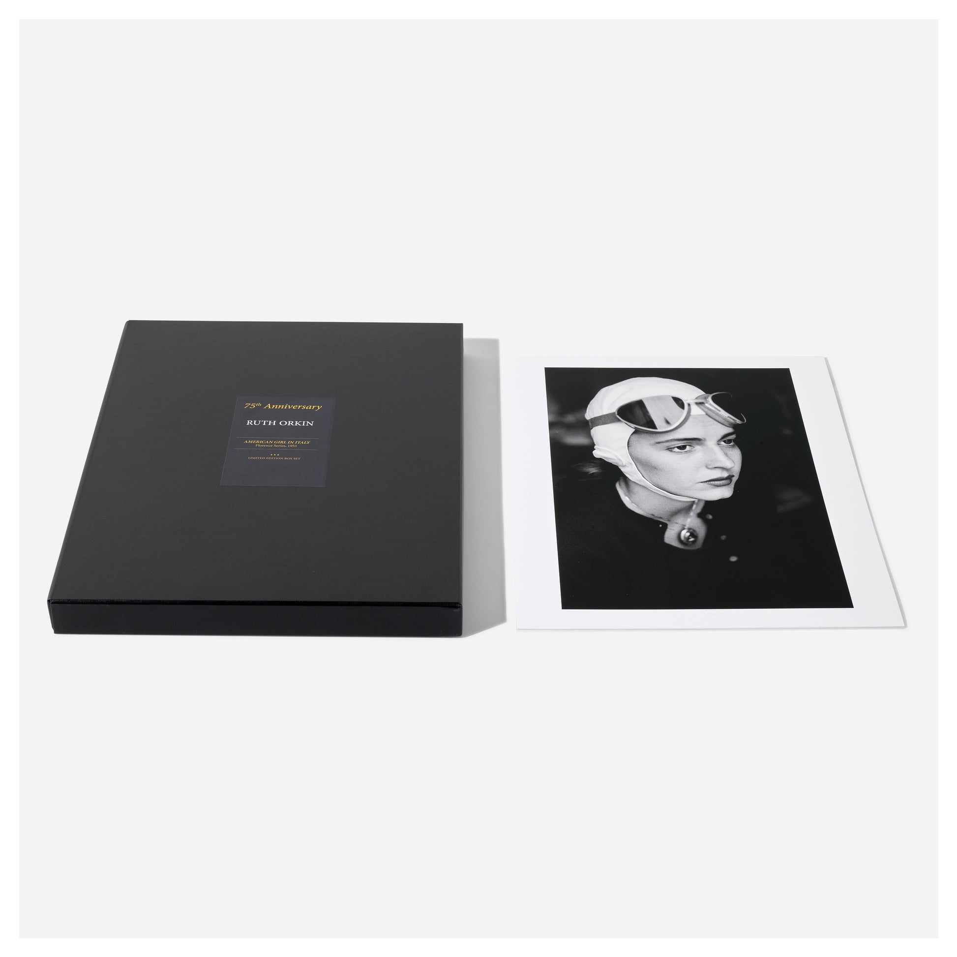 Black portfolio box with a photo of a woman wearing a helmet on a white background from Ruth Orkin's American Girl in Italy.