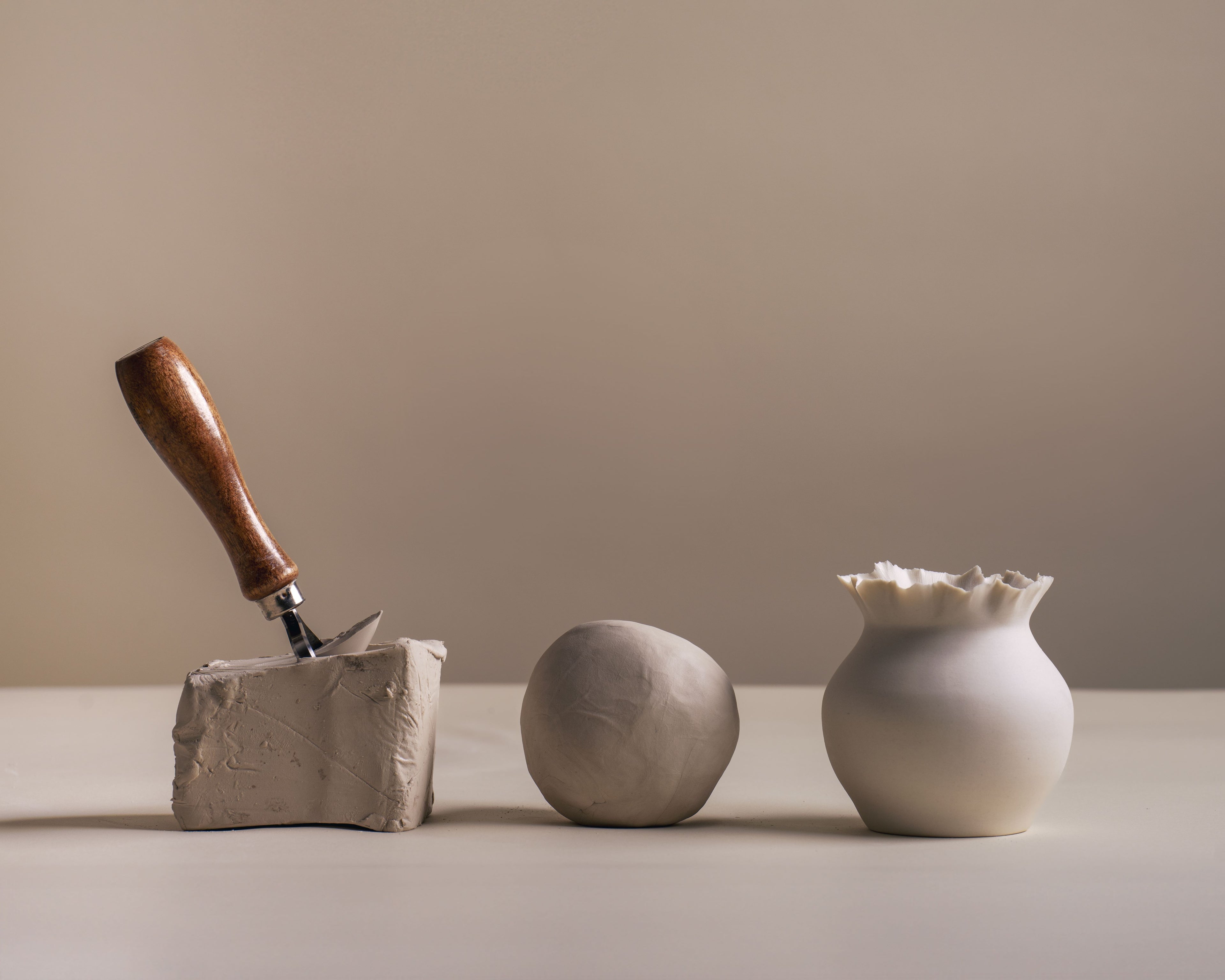 A still life depicting Se Oh's porcelain process from raw clay to a finished Moon Jar